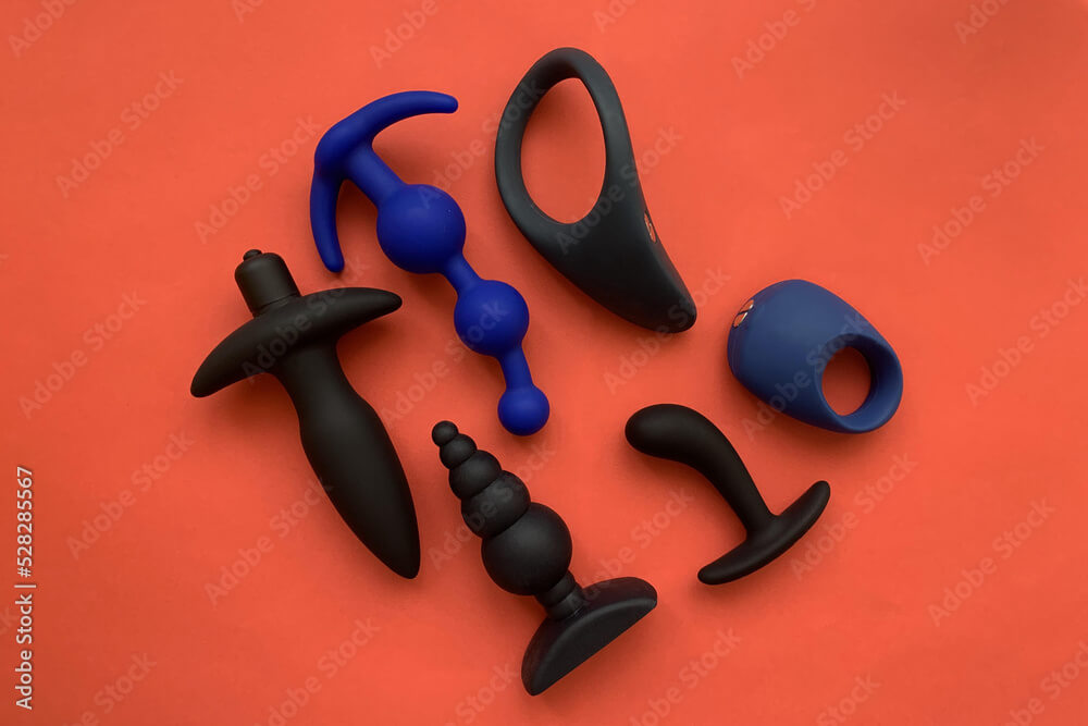 Sex shop assortment. Black sex toys. cock ring, butt plags and prostate  massager. Red background Stock Photo | Adobe Stock